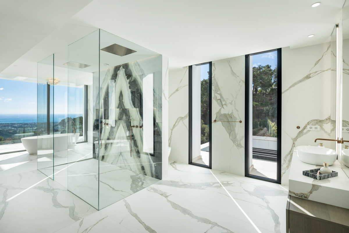 the bathroom. Sea view, brass fixtures, glass everywhere.