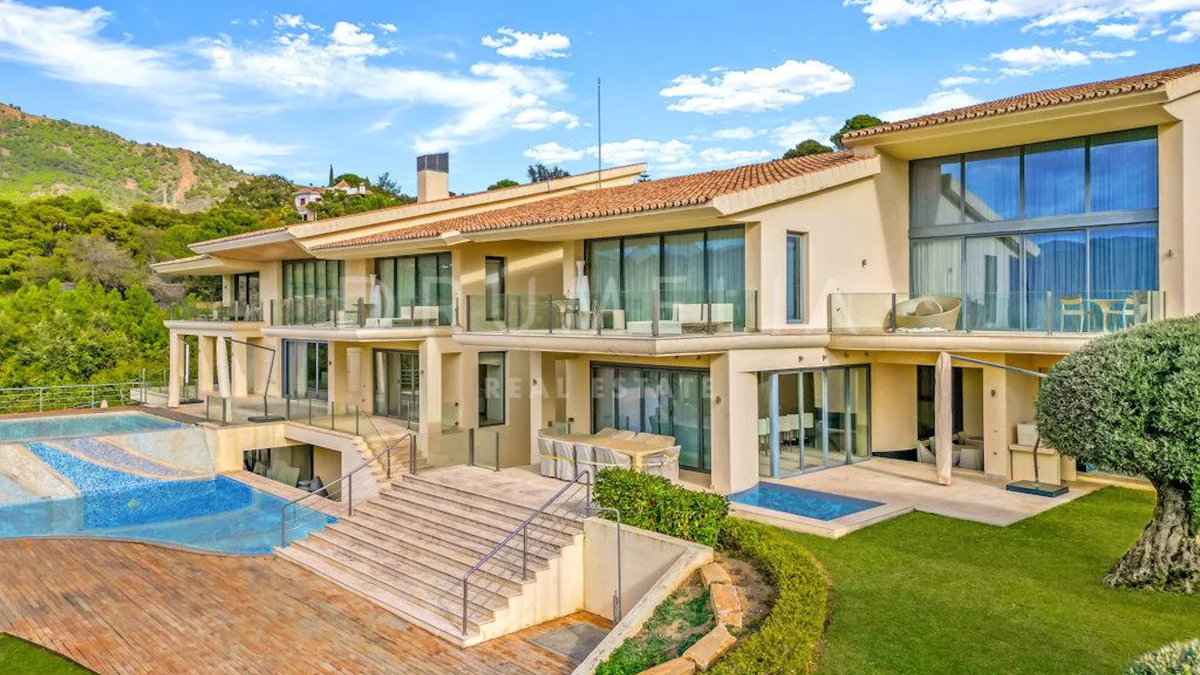 the back of the house. Two floors of glass, a mosaic pool, a lawn with a haircut.